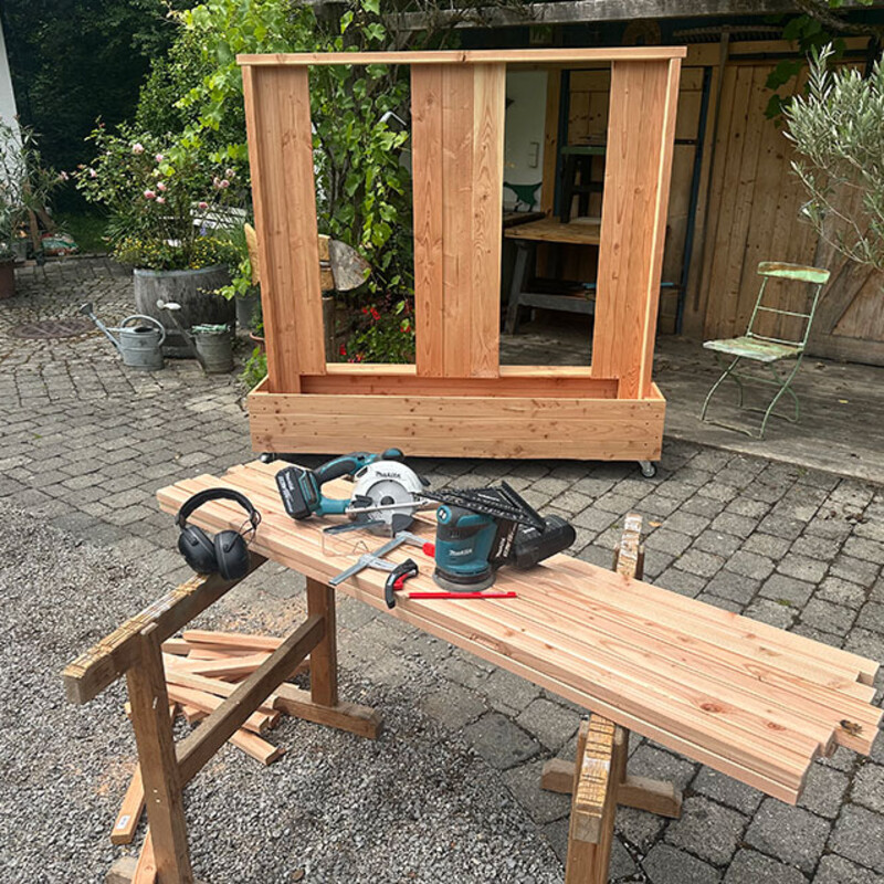 Holzkonstruktion für DIY Sichtschutz mit Werkzeug im Außenbereich