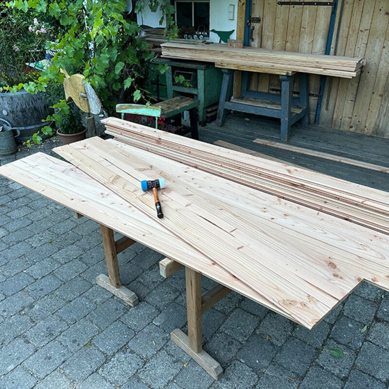 Ein Schonhammer liegt auf Holzbrettern