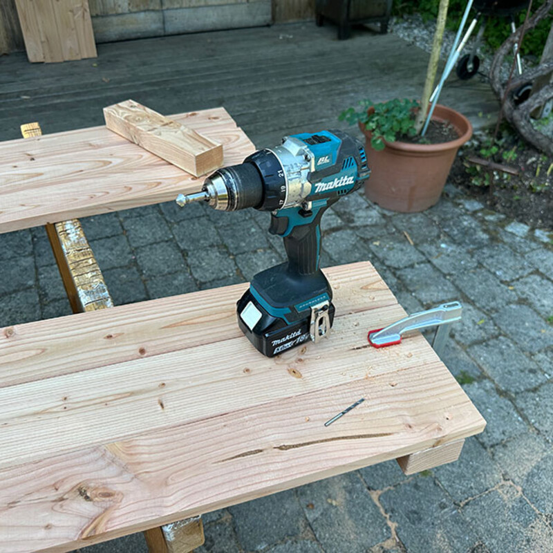 Akkuschrauber liegt auf Holzbrett