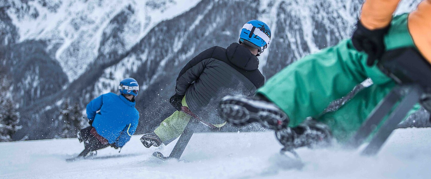 Gruppe von Menschen fährt auf Ski-Böckl die Piste hinunter