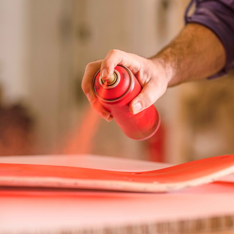 Das Skateboard wird mit rotem Sprühlack eingefärbt