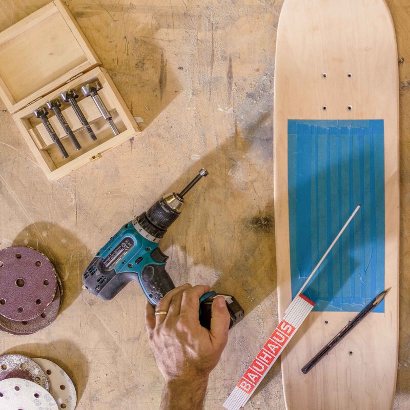 Werkzeuge liegen neben einem alten Skateboard auf dem Tisch