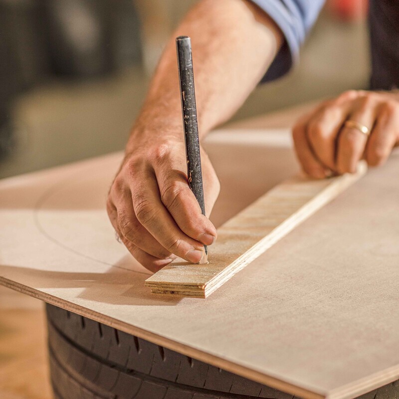 Mit Hilfe eines Bleistifts wird ein Kreis auf die Holzplatte gezeichnet