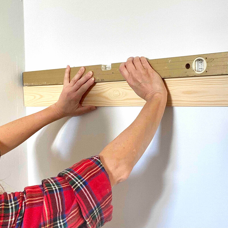 Leiste an Wand mit Wasserwaage prüfen