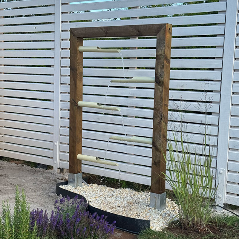Fertiges Wasserspiel vor Gartenzaun