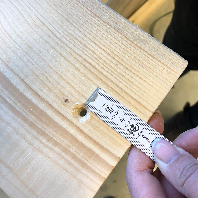 Ausmessen eines Holzbrettes mit Gliedermaßstab