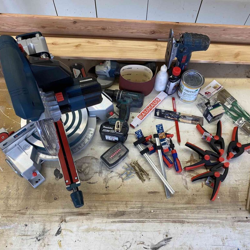 Werkzeuge und Meterialien für den Bau eines Yogamatten-Regals liegen auf einer Werkbank