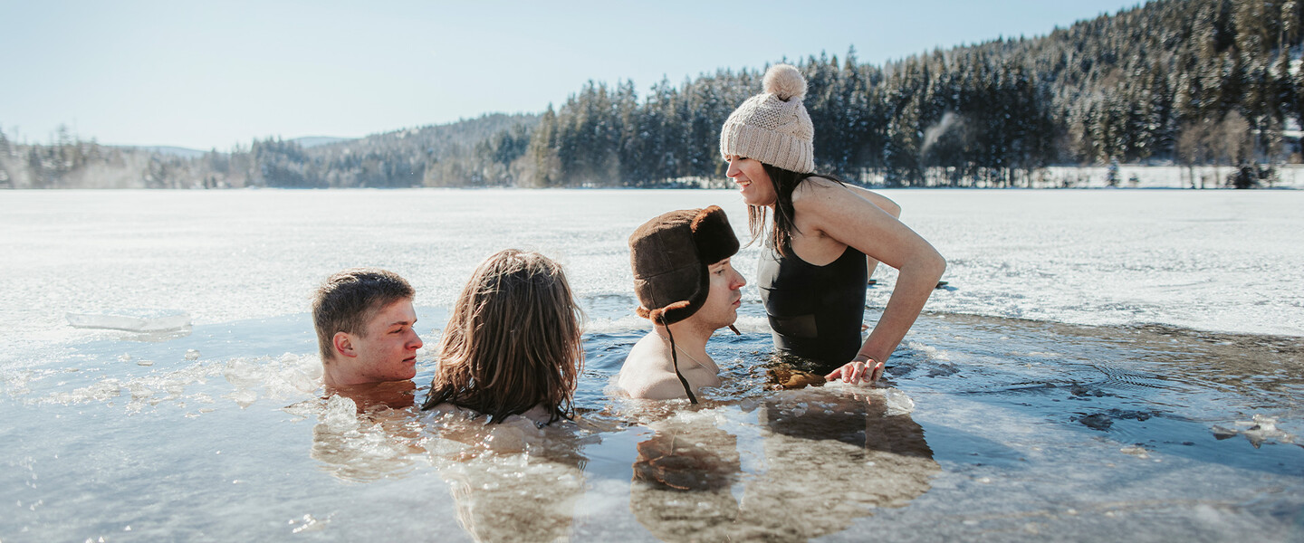 Vier Menschen baden in einem gefrorenen See