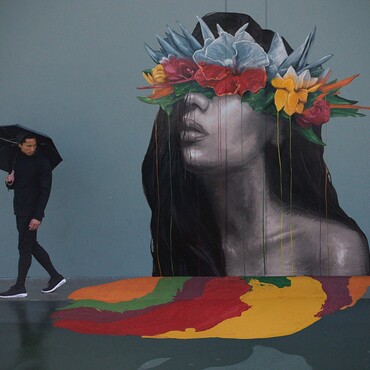 Sean Yoro mit Regenschirm vor Gemälde