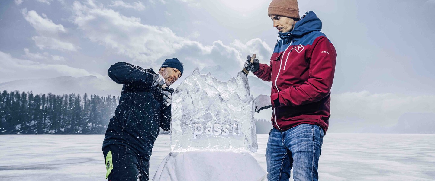 Reto Grond und Alexander Zimmermann bearbeiten Eisskulptur auf einem zugefrorenen See