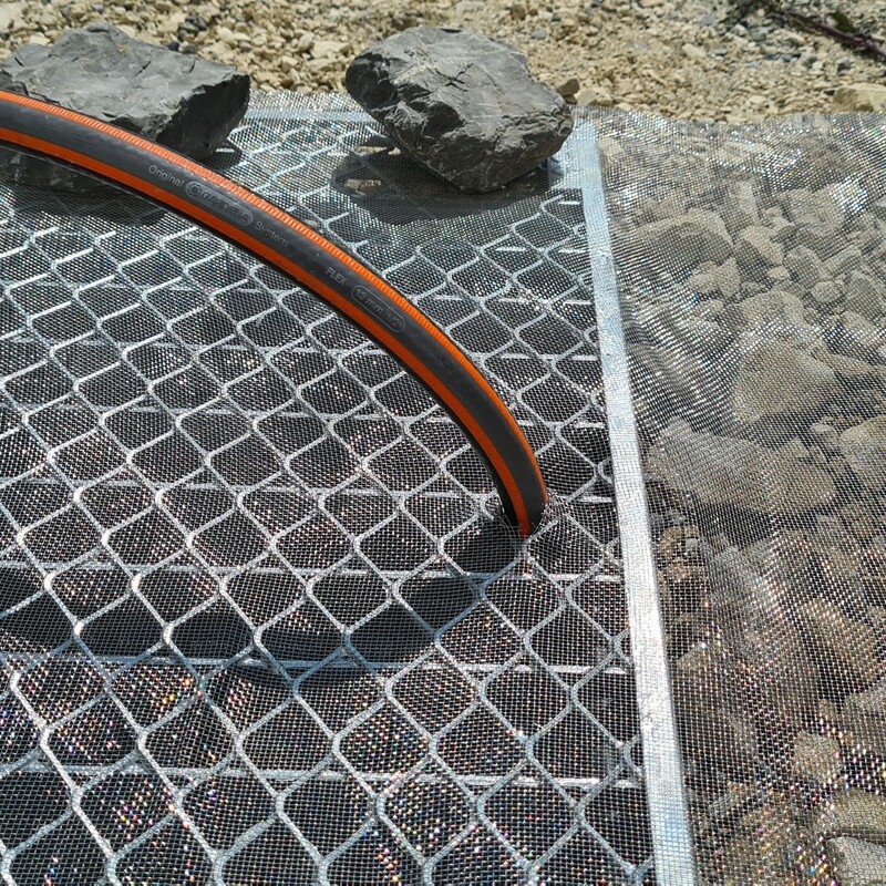 Wasserschlauch im Rost befestigt