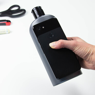 Smartphone wird zur Bestimmung der Größe auf Shampooflasche gelegt