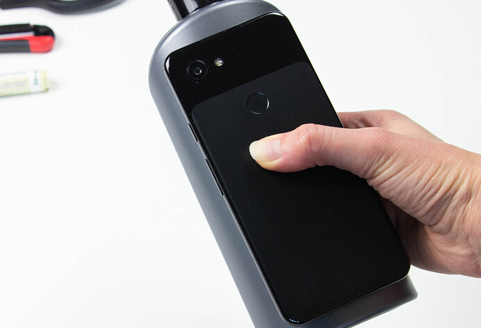 Smartphone wird zur Bestimmung der Größe auf Shampooflasche gelegt