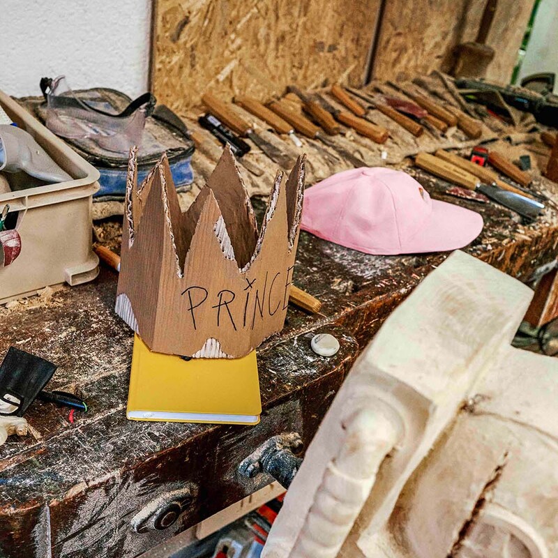 Werkbank in Werkstatt mit einer Krone und einer Mütze aus Holz