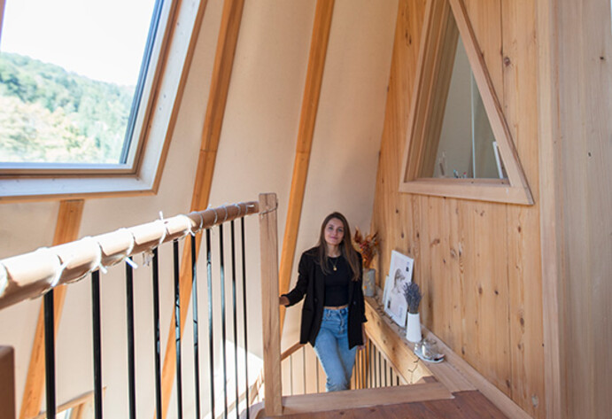 Frau läuft eine Treppe in einem Holzhaus hoch