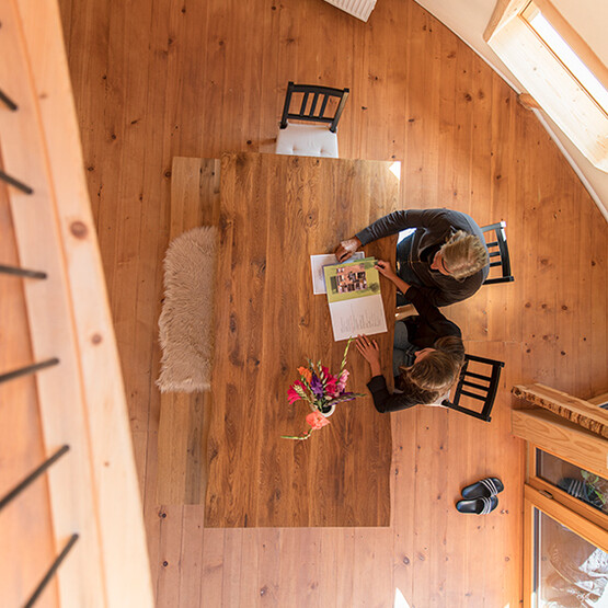 Zwei Menschen sitzen am K&uuml;chentisch und begutachten eine Zeitschrift