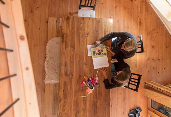 Zwei Menschen sitzen am K&uuml;chentisch und begutachten eine Zeitschrift