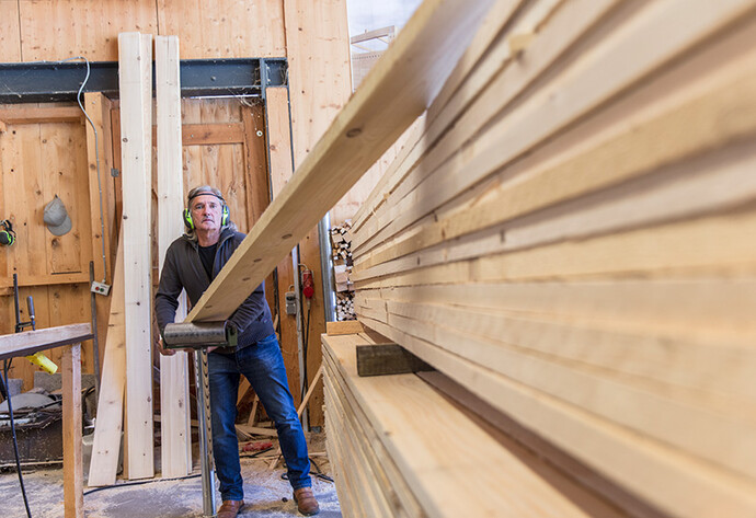 Ein Mann mit Geh&ouml;rschutz arbeitet in einem S&auml;gewerk