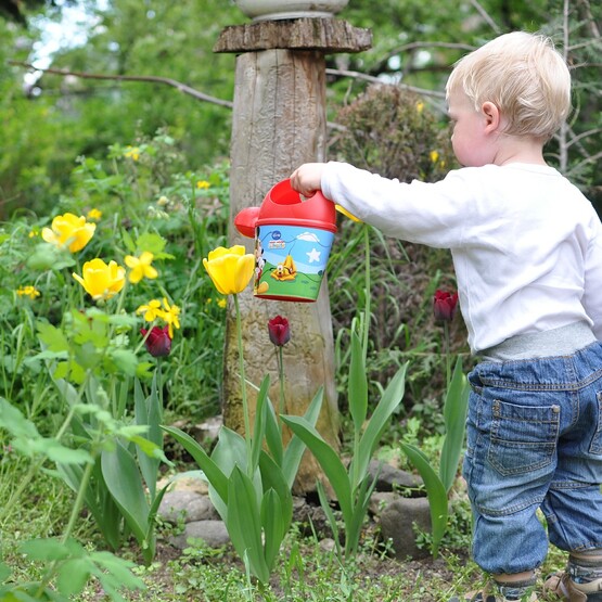 Junge gießt Blumen