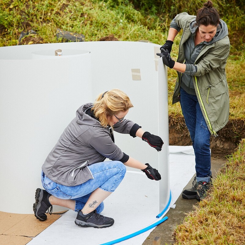 Susanne und Katharina setzen die Stahlwand in die Bodenschiene ein.