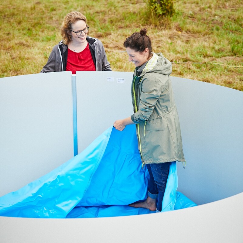 Susanne und Katharina hängen die Innenfolie des Stahlwandpools ein.