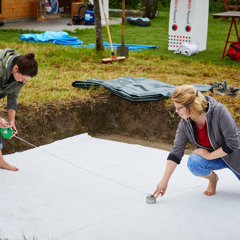 Susanne und Katharina verlegen das Bodenvlies für den Stahlwandpool