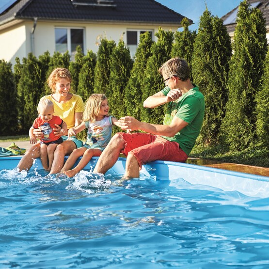 Familie sitzt am Pool