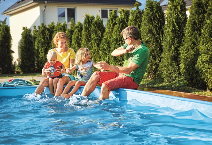 Familie sitzt am Pool