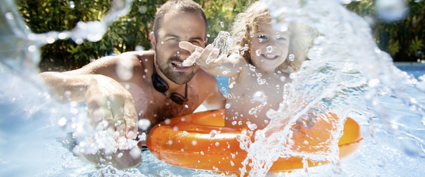 Vater und Kind planschen im Pool