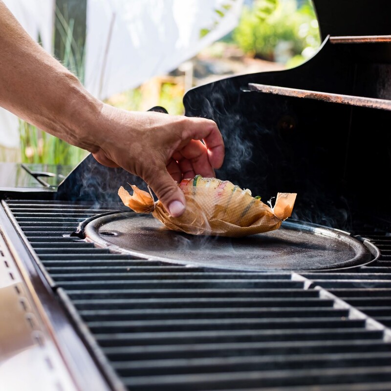 Gefüllte Fächerkartoffeln in Backpapier wickeln und auf die Grillplatte legen