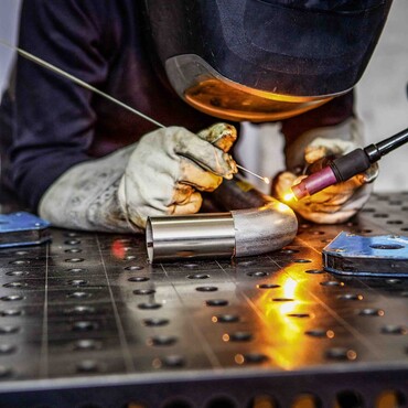 Hannah Kuhlmann mit Schwei&szlig;maske und Stahlrohr