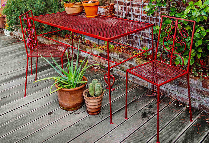 roter Gartenstuhl und Tisch auf Terrasse