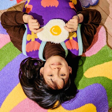 Zeyu Cheng kopfüber auf buntem Teppich