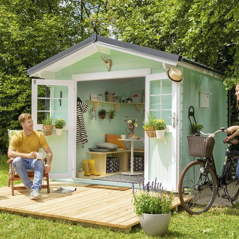 Blockbohlenhaus steht im Garten