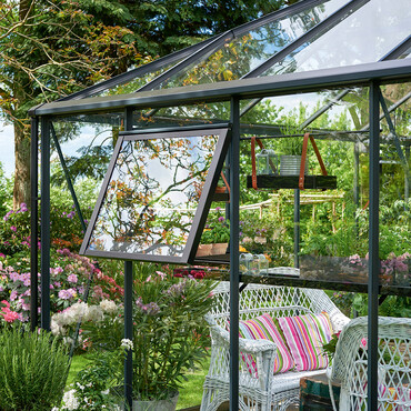 Blick von au&szlig;en in ein gl&auml;sernes Gew&auml;chshaus