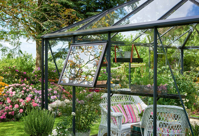 Blick von au&szlig;en in ein gl&auml;sernes Gew&auml;chshaus