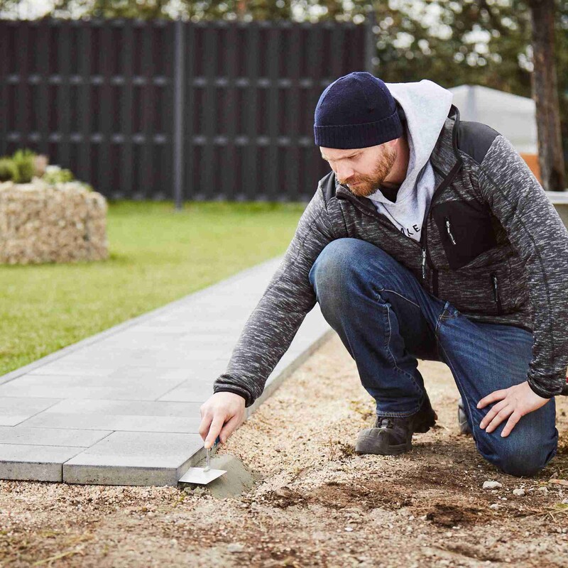 Steinpalttenweg anlegen: Rand des Steinplattenwegs mit Beton absichern