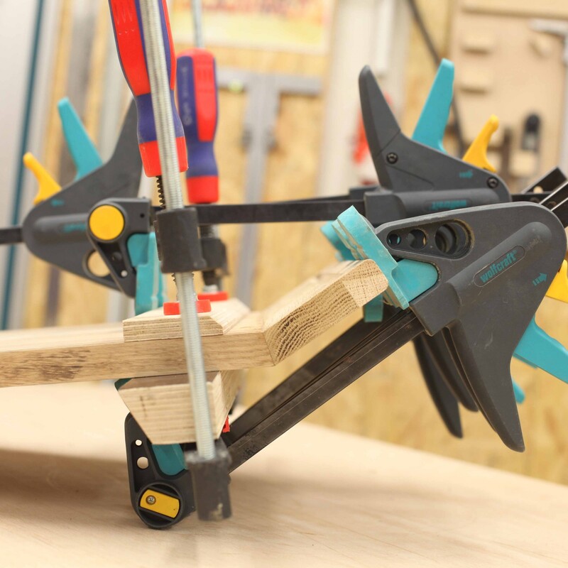 Verklebte Holzstücke sind in einer Zwingen fixiert