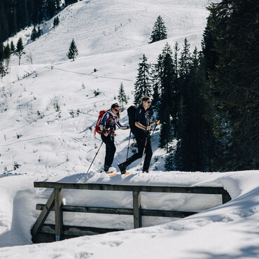 Über eine zugeschneite Brücke wandern