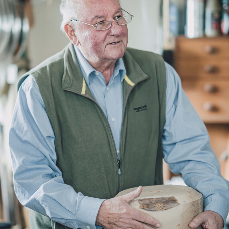 Herr Brandtner hält einen Holzklotz in der Hand