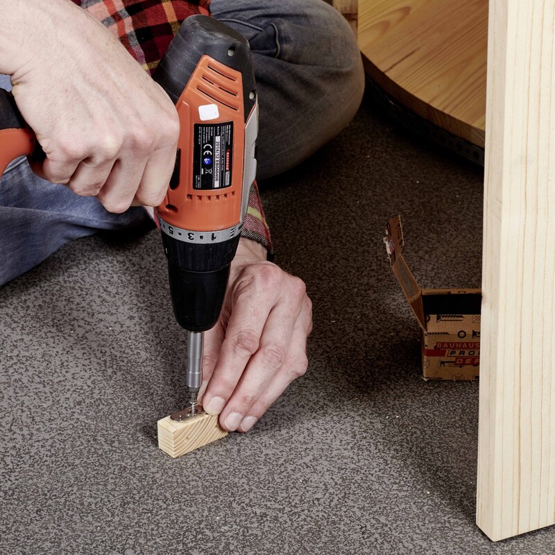 DIY Regentonnenverkleidung: Metallplatten auf Holzklotz schrauben