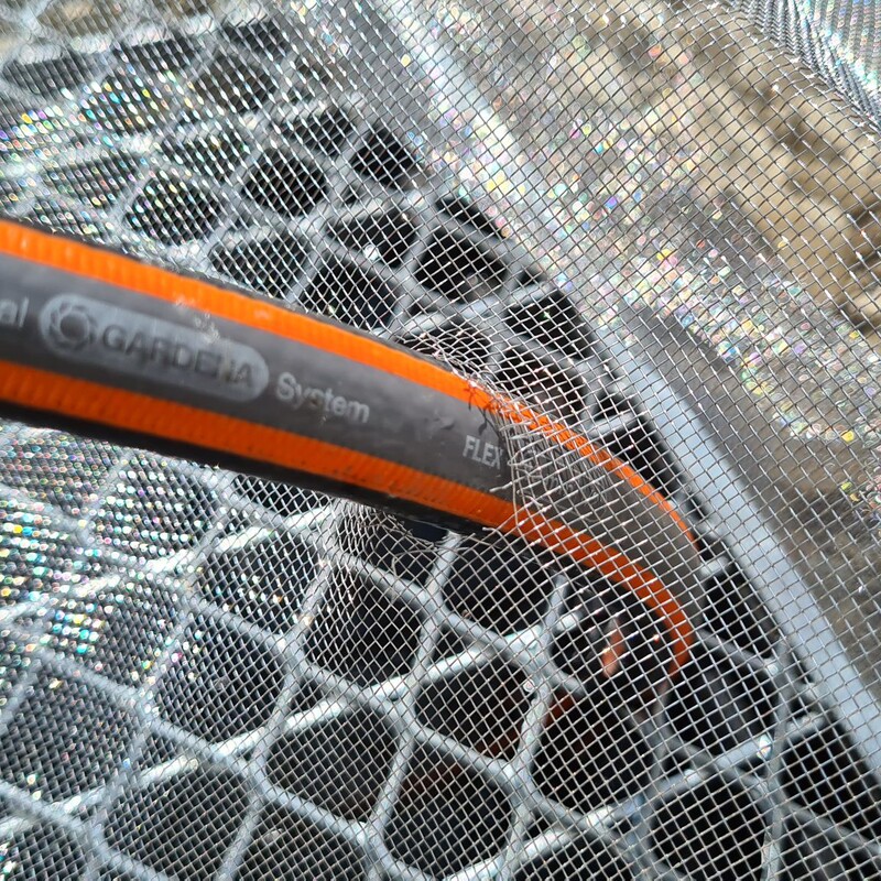 Wasserschlauch durch das Gitter ziehen