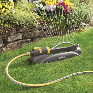 Schwarz-gelber Rasensprenger bew&auml;ssert den Garten