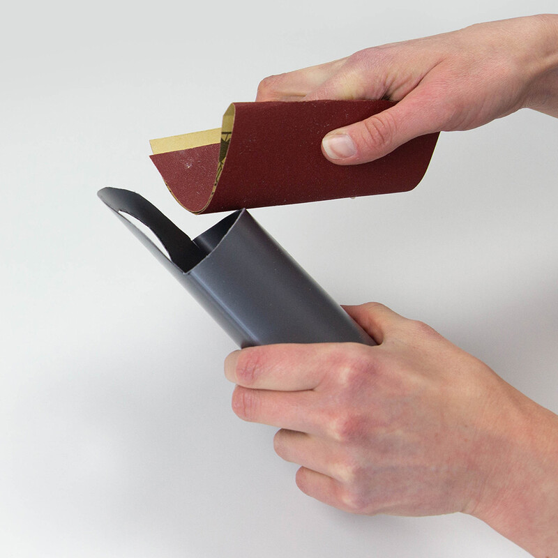 Die Kanten der Ladestation werden mit Schleifpapier abgerundet