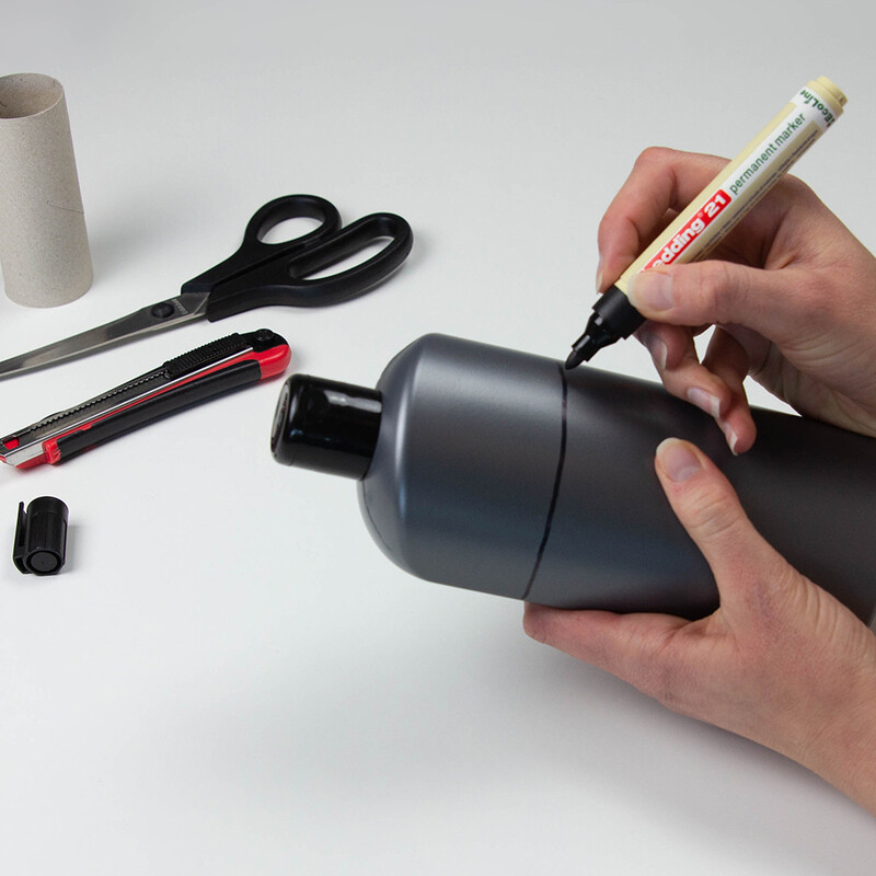 Shampooflasche in Hand wird mit schwarzem Edding markiert