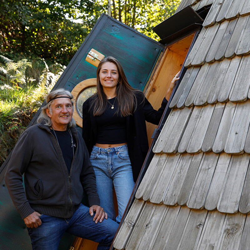 Vater und Tochter stehen neben einem Holztipi