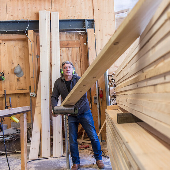 Ein Mann mit Gehörschutz arbeitet in einem Sägewerk