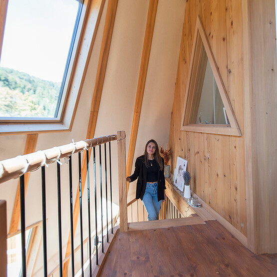 Frau läuft eine Treppe in einem Holzhaus hoch