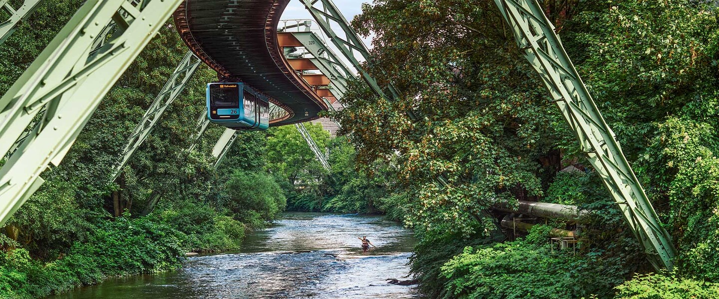 Mann f&auml;hrt Kanu auf der Wupper unter der Schwebebahn