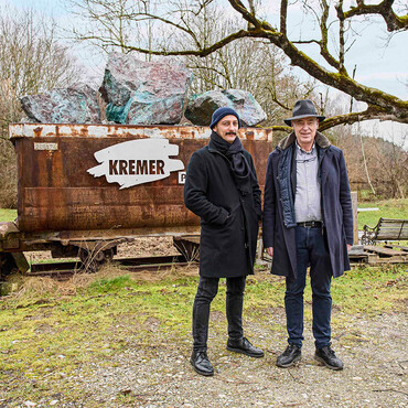 David und Georg Kremer vor Firmenlogo